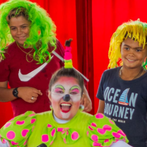 palhaça posando com dois estudantes